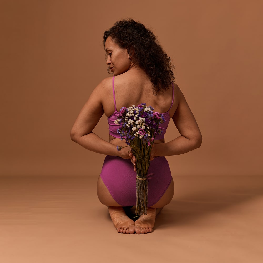 Emotionales Bild einer Frau von hinten mit Blumenstrauß in den Händen